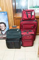 Full view of six luggage pieces stacked showing colors and styles.