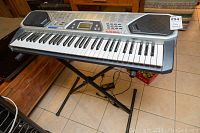 Full view of the Radio Shack MD-982 keyboard on a stand, showing the piano keys, built-in speakers, and control panel.