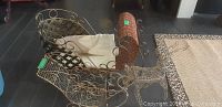 Metal and wicker Christmas sleigh showing basket seating and metal scrollwork.