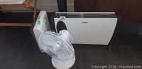 Three appliances arranged on the floor: Noma heater, white oscillating fan, and a Mastercraft heater.