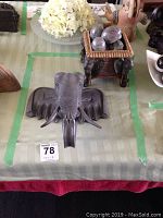 Top view of the elephant head wall mount and the decorative box with stone eggs on the table.
