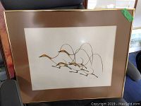 Close-up of abstract and still life framed prints stacked, showing gold frames, green matte and broken glass on one