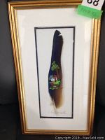 Framed hand-painted feather in gold frame showing full art piece and matting.