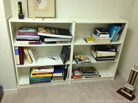 Two white bookcases filled with books and items for scale, showing overall structure and condition.