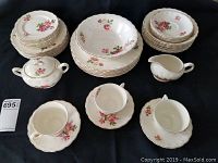 Full set overview showing all plates, cups, sugar dish, creamer, and vegetable bowl arranged on black surface.