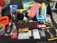 Overview of all hardware items including tape, lights, ropes, and miscellanea in and around a black woven basket