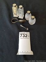 All items together on black cloth including the shakers and silver spoons with a MaxSold tag