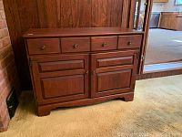 Wood dining room sideboard with four upper drawers and two lower cabinet doors, dark polished wood finish.