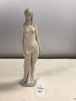 Full front view of the figurine standing on a base with scarf