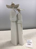 Side view of two nuns porcelain figurine showing front details and rosaries.