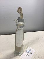 Front view of Lladro figurine showing girl holding lamb with soft colors and glossy finish.