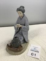Front view of Lladro Japanese girl serving tea porcelain figurine, showing girl kneeling with tea cup and kettle on tray.