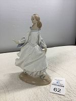 Porcelain figurine front view showing dancing girl with flowing dress and lost shoe.