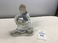 Front angle view of Nao Lladro Girl with Aching Feet porcelain figurine showing seated girl and basket