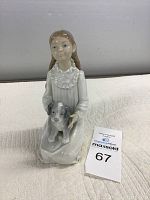 Front view of Nao girl holding dog porcelain figurine on beige surface with auction tag.