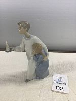 Side angle view of the Lladro porcelain figurine showing two boys, one holding a candle.