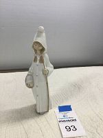 Front view of Lladro porcelain figurine of girl wearing hooded coat, holding stick and basket.