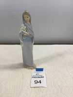 Front angle view of the Lladro girl figurine holding flowers