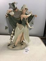 Front view of the porcelain figurine showing the couple in costume, man holding a lantern