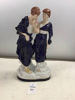Front view of Royal Dux porcelain figurine showing full body of Roman couple, man holding flower, woman beside him.