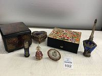 Photo showing all vanity decor items together on a white surface including jewelry boxes, perfume bottles, and a small dish on a stand.
