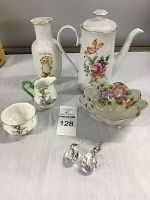 Photo showing entire assortment of china items, porcelain vase, decorative bowl, and earrings arranged on a surface.