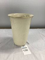 Full front view of 10-inch cream-colored Lenox vase with embossed leaf pattern and gold rim.