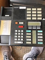 Single Nortel Norstar EXT32 reception phone showing numeric keypad, function buttons, small LCD screen, and handset.
