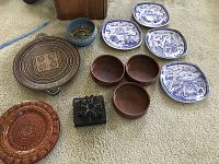 Overview of all 11 decorative ceramics and decor items on beige carpet, showing plates, bowls, trays, and candelabra base