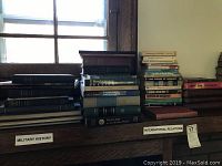 Stack of military history books labeled under 'Military History' and 'International Relations' categories, showing various vintage and hardcover editions.