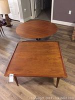 Both tables displayed on hardwood floor with lamp in background