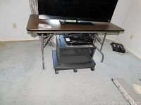 Photo of collapsible table showing full rectangular tabletop and metal legs.