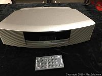 Front view of silver Bose Wave Music System III on black surface with remote