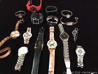 Lot of 15 assorted quartz watches in various styles and bands including metal, leather, and plastic looking straps