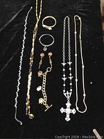 Full view of all costume jewelry items arranged on black fabric, including necklaces, bracelets, earrings, showing size and detail.