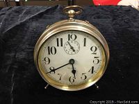 Front angle view of the vintage Westclox Big Ben alarm clock on a black cloth background showing the dial and metal body.
