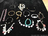 Overview of all 15 pieces including necklaces and bracelets with various colors and charm details.