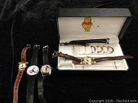 Four vintage Disney watches displayed on black background, including 2 Mickey Mouse, 1 Winnie the Pooh, and 1 Goofy.