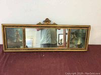 Full view of the rectangular antique mirror showing gold frame with side prints and central reflective glass.