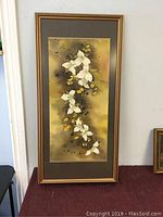 Full view of framed watercolour painting depicting white and yellow flowers on a muted background.