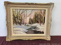 Framed oil painting showing overall view of winter landscape with snow and creek, capturing the full artwork and frame details.