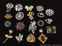 Top down photo of all 20 brooches arranged on black background