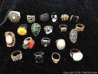 Twenty assorted rings arranged in four rows on black background