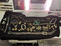 Full assortment of rhinestone jewelry including earrings, necklaces, brooches, hair and shoe clips on black fabric.