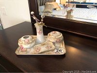 Full view of the vintage dresser set on a dark wood surface with mirror background showing vase, containers, tray, and dish