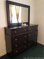 Wide view of dark brown dresser with attached large rectangular mirror
