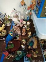 Various bird figurines including cardinals, owl, bluejay, duck, and handmade wood roses arranged on table.