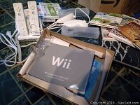 Wii console box with Wii Operations Manual and other paperwork visible inside.