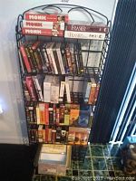 Photo of black metal rack filled with audiobook CD boxed sets and cases including Monk, Frasier, and various others.
