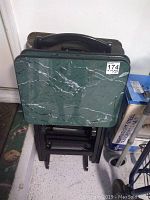 Front view of the set showing the green marbled top of the tray and black folding carrier beneath.